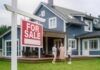 Congress Slams Wall Street Home Grabs For sale sign in front of a house with potential buyers discussing
