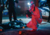 Forensic investigator examines crime scene at night.