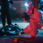 Domestic Call Erupts Into Deadly War Zone Forensic investigator examines crime scene at night.