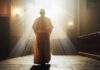 Person in religious attire bathed in sunlight.
