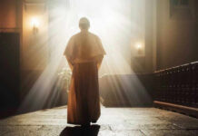 Person in religious attire bathed in sunlight.