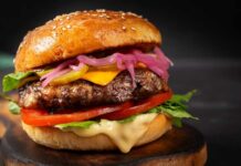 Backyard Burger Becomes A Tax? Close-up of a gourmet cheeseburger with lettuce, tomato, and pickled onions