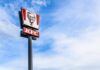 Sauce Tsunami Hits KFC KFC restaurant sign against a blue sky