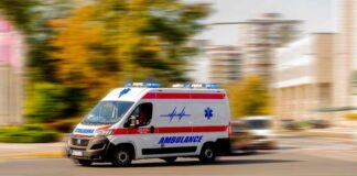 Ambulance van with flashing lights speeding through a city street