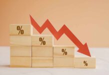 Savings Freefall Signals Quiet Crisis Wooden blocks with percentage symbols and a downward arrow indicating decline