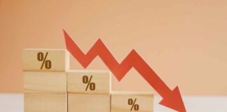 Wooden blocks with percentage symbols and a downward arrow indicating decline