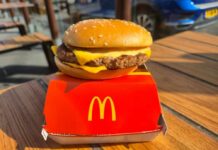 McDonald’s Plays Patriotism With A Fan Favorite A cheeseburger from McDonald's placed on a red box on a wooden table