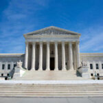 Supreme Court Hands Trump Big Immigration Win U.S. Supreme Court building under clear blue sky.