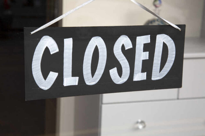 Closed,Sign,On,Shop,Window A black sign with the word 'CLOSED' painted in white letters