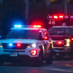 Hitler House Flips — Cops Move In Police car and ambulance with flashing lights nighttime