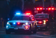 Hitler House Flips — Cops Move In Police car and ambulance with flashing lights nighttime