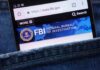 FaceTime Con: Watch Them Drain Accounts Mobile phone displaying the FBI website in a denim pocket
