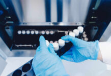 DNA Bombshell Nails Texas Mom Person in blue gloves handling test tubes in a laboratory