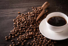 Coffee Shock: AHA Backs Five Cups A cup of hot coffee next to spilled coffee beans and a wooden scoop