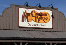 Cracker Barrel Axes THESE Restaurants — Why Now? Sign for Cracker Barrel Old Country Store featuring a man sitting on a barrel