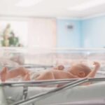 Leftist Media Pounces On THIS Baby?! Newborn baby lying in a transparent crib in a hospital nursery