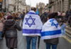 Netanyahu Arrest Fantasy Collides With Law People wearing Israeli flags at a street protest