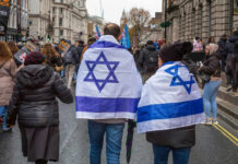 People wearing Israeli flags at a street protest