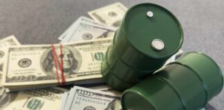 Two green barrels placed on a pile of hundred dollar bills