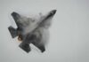 Russian Bomber Dares Flagship Aircraft Carrier Fighter jet performing an aerial maneuver with smoke trailing behind