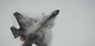 Fighter jet performing an aerial maneuver with smoke trailing behind
