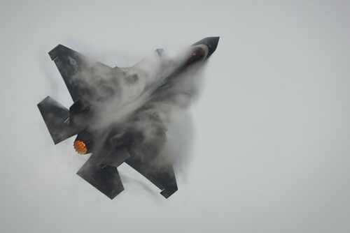 Thailand,Bangkok,-07,March:,Us,Air,Force,F-35a,Fighter,Jet Fighter jet performing an aerial maneuver with smoke trailing behind