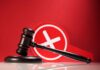 Appeals Court Freezes Trump’s Push Judge's gavel with a red cross symbol in the background