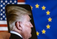 Trump Threatens Full Europe Pullout Profile view of a man displayed on a smartphone in front of American and European flags
