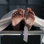 Death Toll Whiplash Stuns Venezuela Feet of a covered body on a morgue table with a toe tag