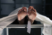 Death Toll Whiplash Stuns Venezuela Feet of a covered body on a morgue table with a toe tag