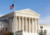 Supreme Showdown: AR-15 Bans On Trial U.S. Supreme Court building with American flag.
