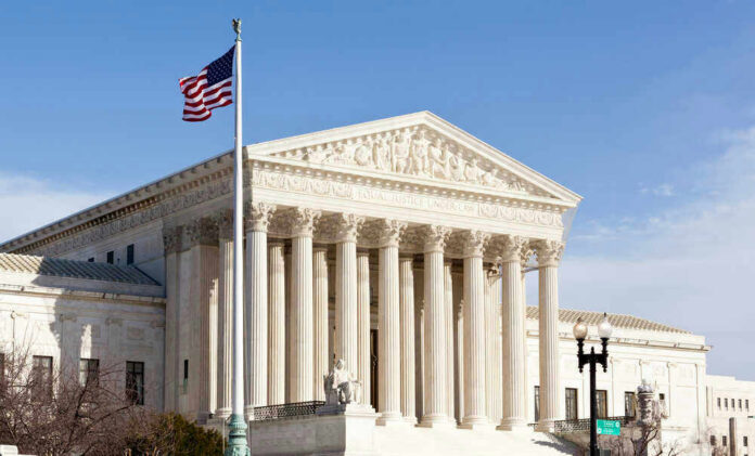 shutterstock_96721225 U.S. Supreme Court building with American flag.