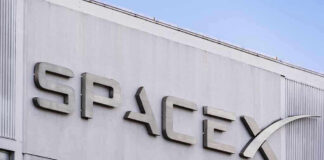 SpaceX building logo against blue sky.