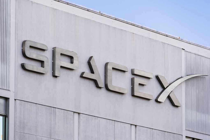 1589390272 SpaceX building logo against blue sky.
