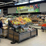 People shopping and cleaning inside an Aldi supermarket.