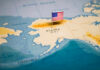 Map of Alaska with a small American flag