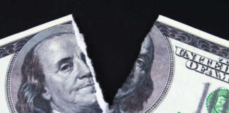 A torn hundred dollar bill featuring Benjamin Franklin