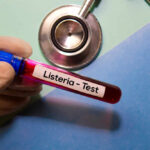 Walmart Soup Yanked Over Scary Listeria Hint A gloved hand holding a blood test tube labeled 'Listeria - Test'