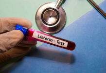 Walmart Soup Yanked Over Scary Listeria Hint A gloved hand holding a blood test tube labeled 'Listeria - Test'
