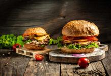 Gourmet burgers on rustic wooden boards with fresh toppings