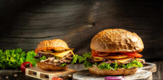 Gourmet burgers on rustic wooden boards with fresh toppings