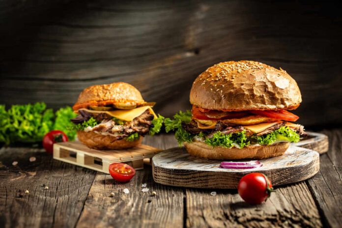 Tasty,Grilled,Homemade,Burgers,With,Beef,,Tomato,,Cheese,,Bacon,And Gourmet burgers on rustic wooden boards with fresh toppings