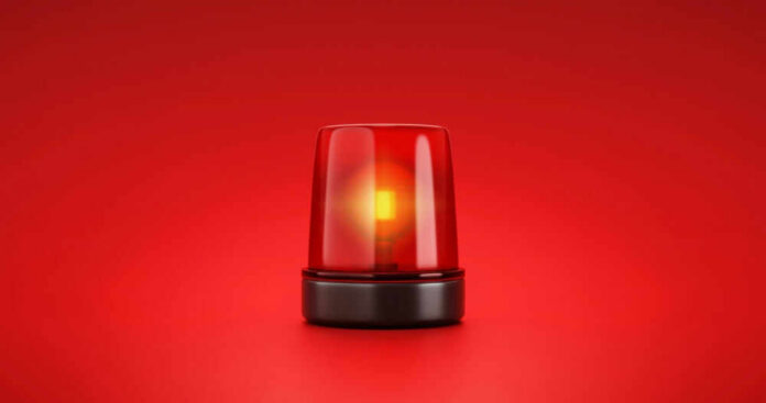 shutterstock_2053758056 Red emergency light on red background