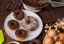 Milk Bomb in Donut Aisle Chocolate glazed donuts on a patterned plate with baking ingredients