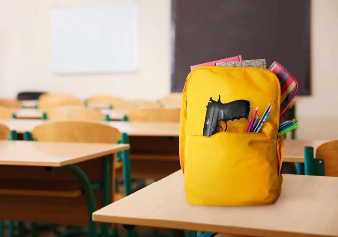 School,Shooting.,Backpack,With,Gun,And,Stationery,In,Classroom A yellow backpack with a gun partially visible in a classroom setting