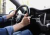 Hands gripping a steering wheel inside a car
