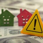Rich Buyers Feast, Starters Stall Colorful house models and a warning sign on dollar bills