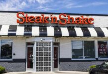 Exterior view of a Steak 'n Shake restaurant with a striped awning