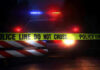 Small-Town Bloodbath Stuns State – 6 Dead Police car with flashing lights behind caution tape.