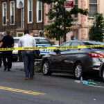 Lib City Mass Shooting – 7 Victims Police and crime scene tape on city street.
